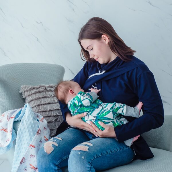 Woman breastfeeding baby in maternity blouse