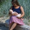 Woman breastfeeding baby on beach